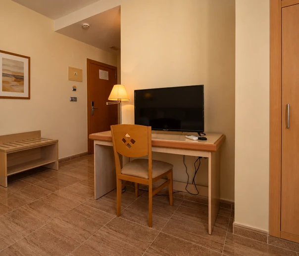 Televisión y escritorio en una habitación de Hotel La Torre